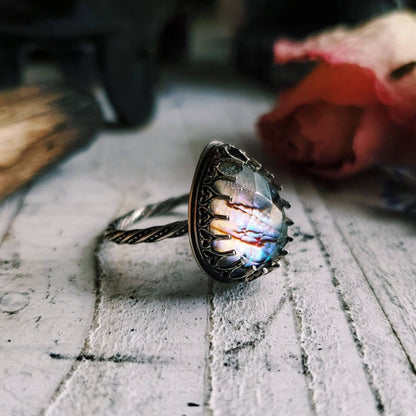 a ring with a rainbow colored stone in it