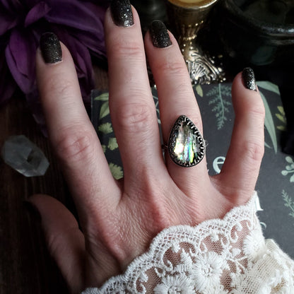 a woman’s hand with a ring on it