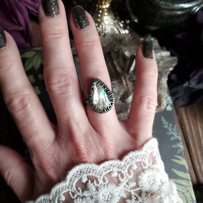a woman’s hand with a ring on it