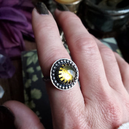 a person wearing a ring with a yellow bird on it
