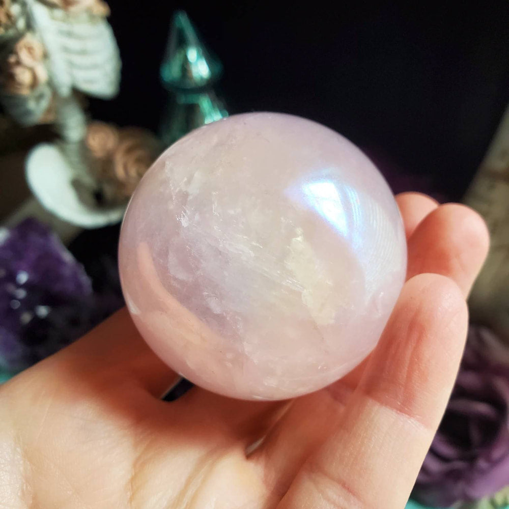 a person holding a large pink quartz ball