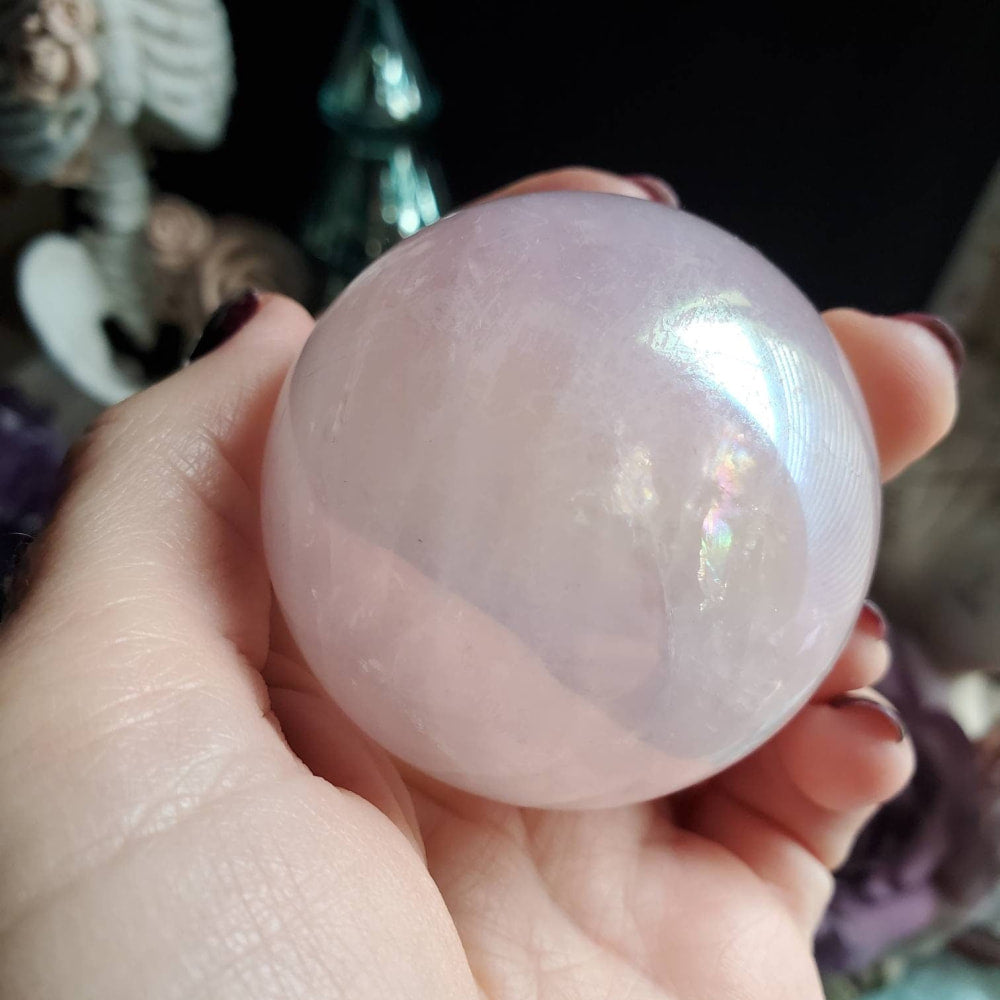 a person holding a pink quartz ball