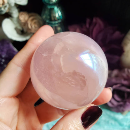 a person holding a pink quartz ball
