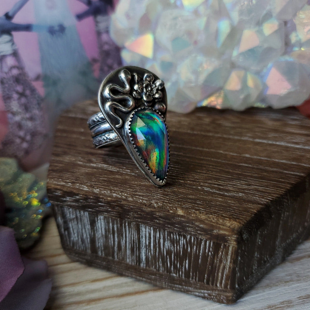 a ring with a rainbow colored stone in the middle