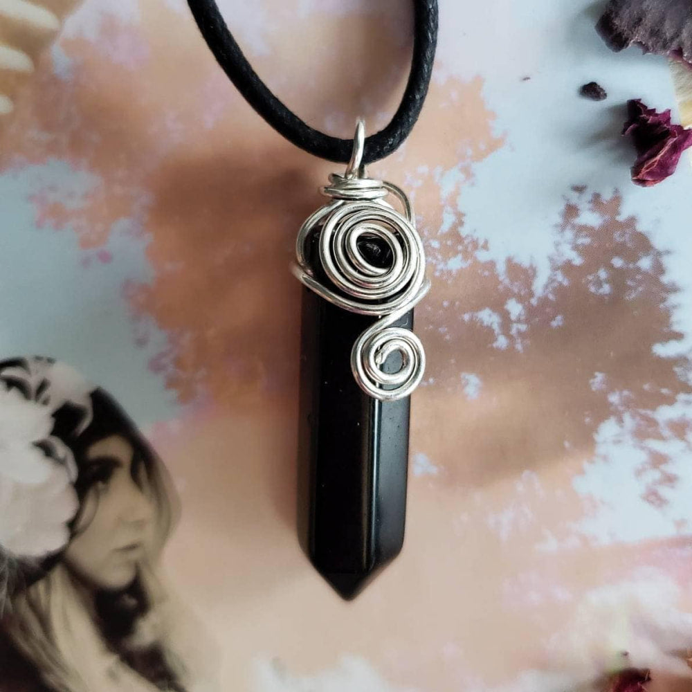 a black stone pendant with a spiral design on it