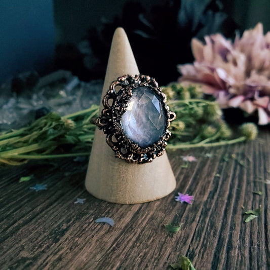 a ring with a large blue stone surrounded by a flower