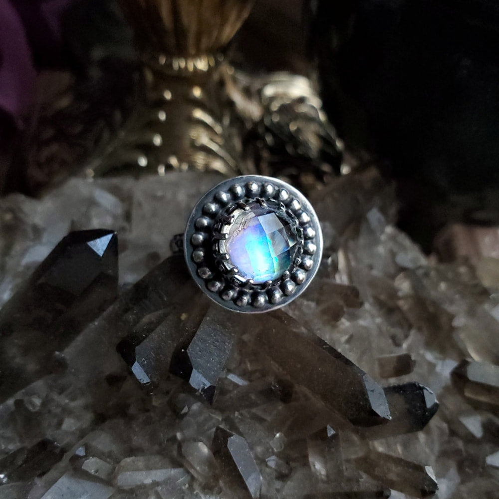 a ring with a rainbow colored stone in the center