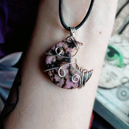a woman’s arm with a bracelet made out of pink and black marble