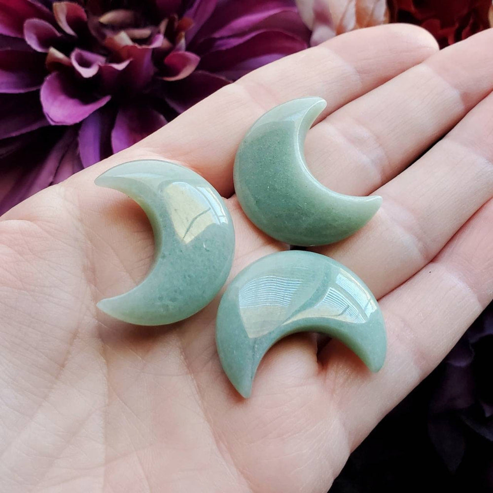 two green jade crescents on a hand
