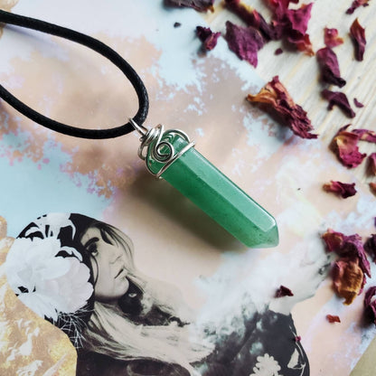 a green jade pendant on a black cord necklace