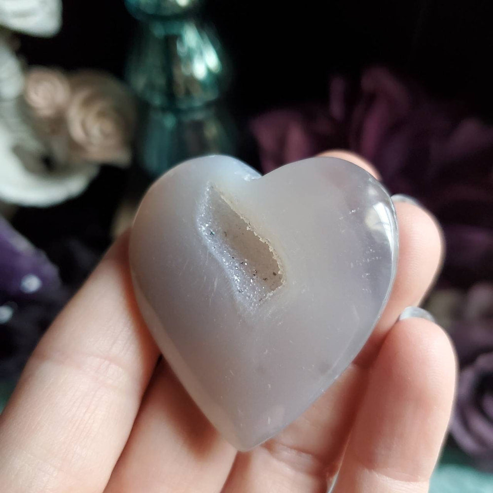a person holding a heart shaped piece of ice