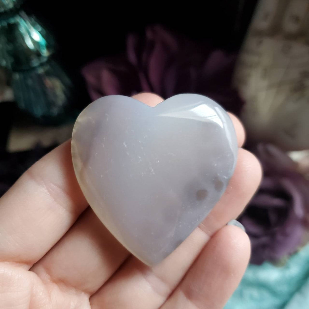 a heart shaped quartz stone in a hand