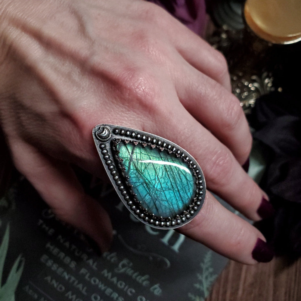 a close up of a person’s hand with a ring on it