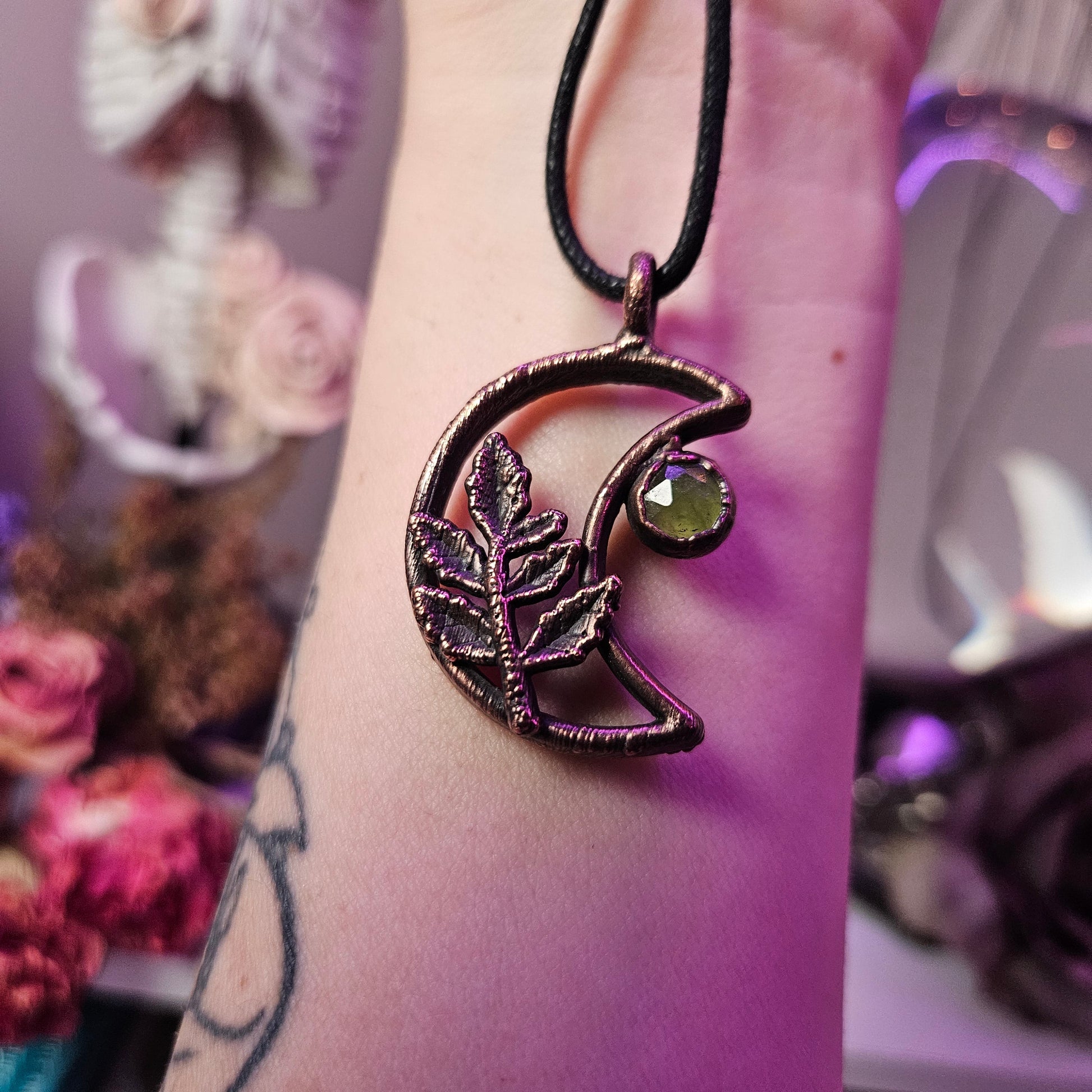 a woman’s arm with a purple bracelet and a purple flower