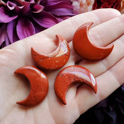 three red moon shaped soaps in a hand
