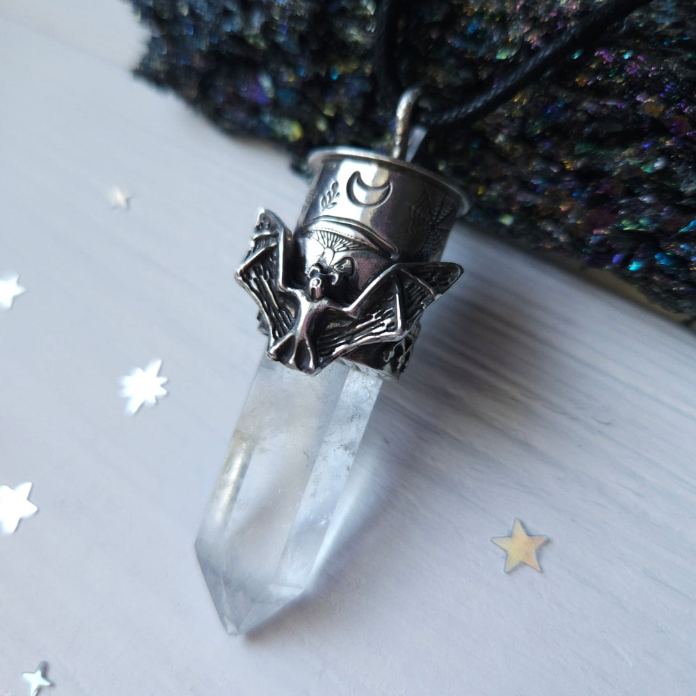 Crystal pendant with a bat-themed silver cap featuring a moon symbol.