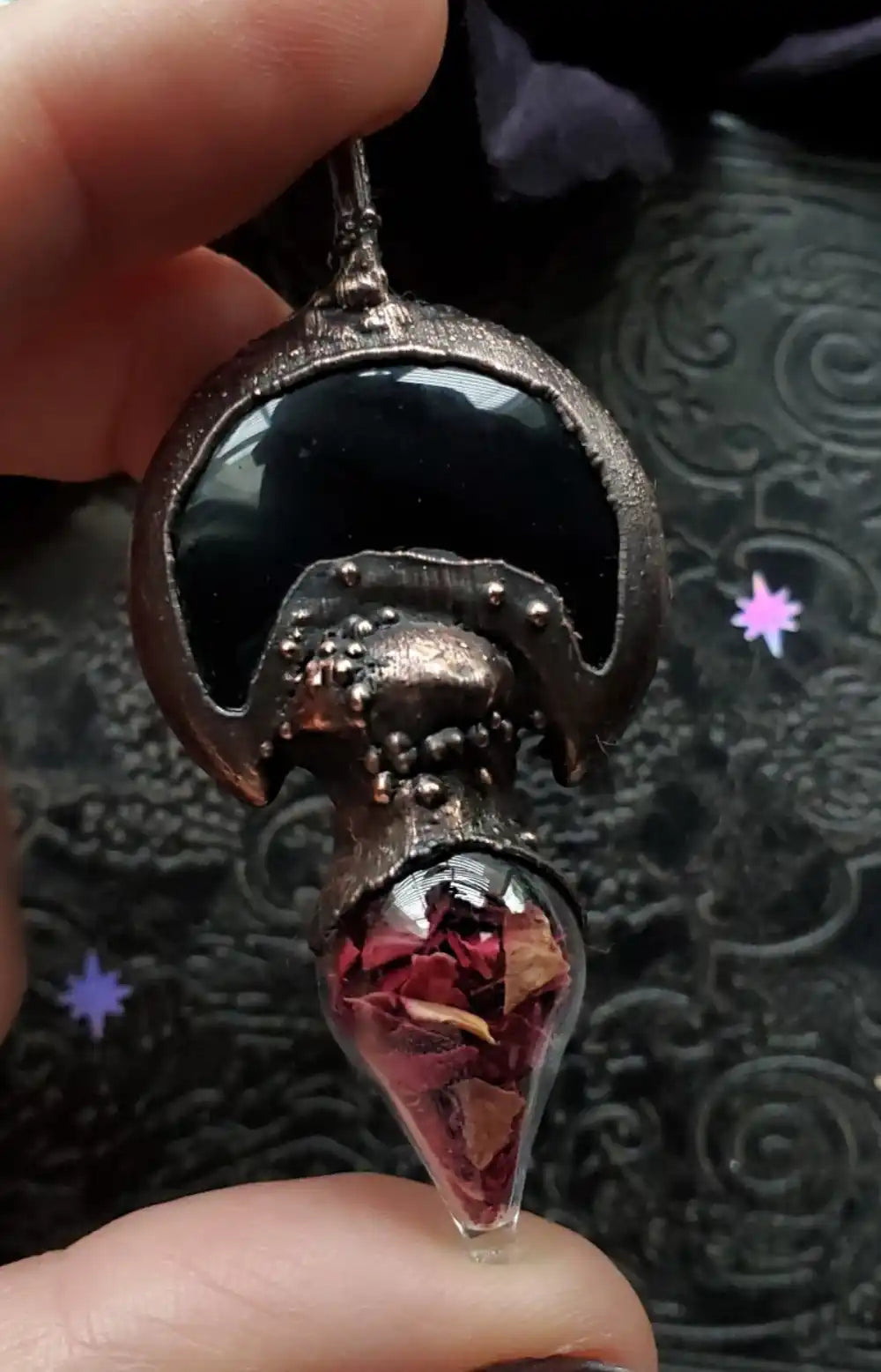 Unique pendant with black stone and rose petals.