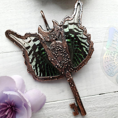 a butterfly shaped mirror with a key on it