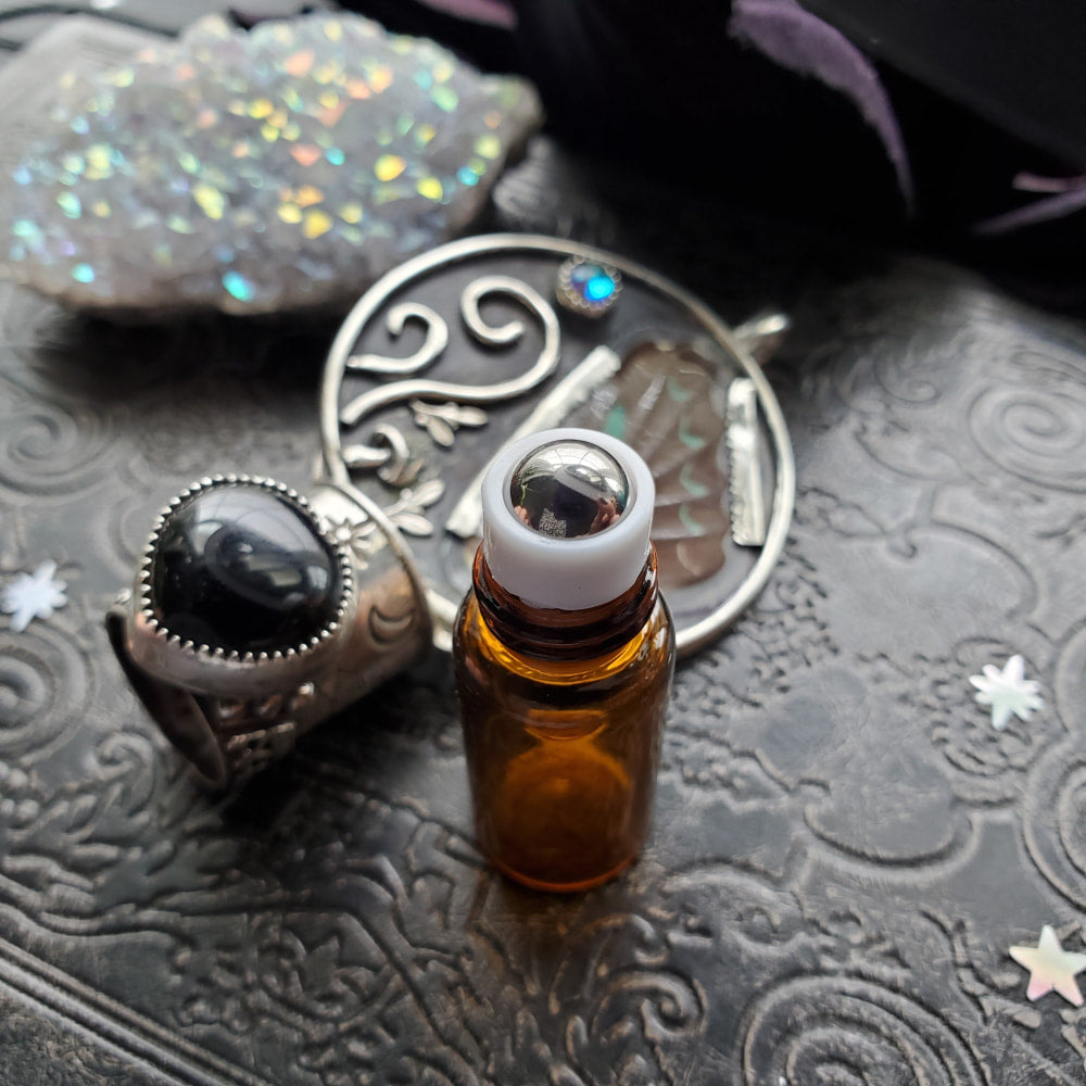 a bottle of essential oil with a silver spoon and a silver spoon