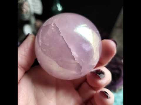 Hand rotating aura rose quartz crystal ball.